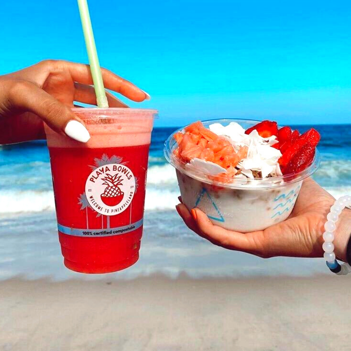 coconut bowl and red juice held over ocean