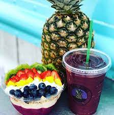 purple smoothie next to acai bowl and pinnaple